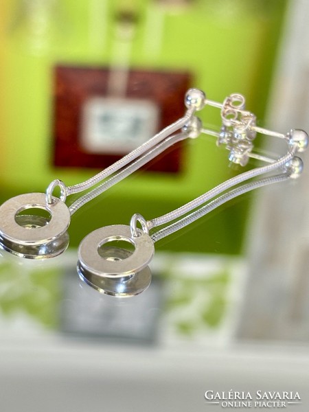 A pair of shiny, dangling silver earrings