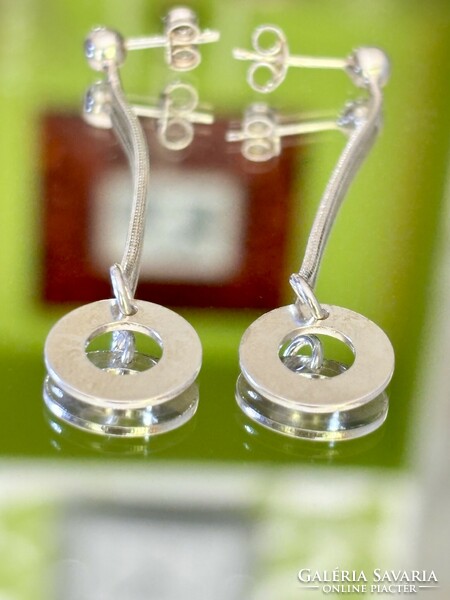 A pair of shiny, dangling silver earrings