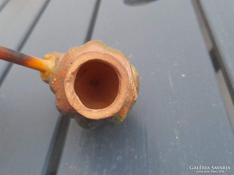 A very old hard earthenware pipe marked with a reed stem