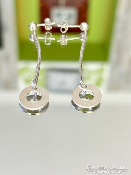 A pair of shiny, dangling silver earrings