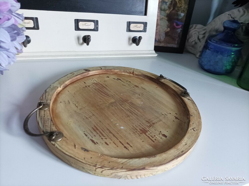With a diameter of 30 cm, a rustic, worn round wooden tray with copper handles