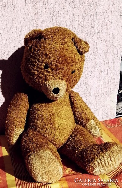Antique large teddy bear stuffed with straw. Moving with rotating limbs