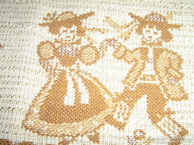Beautiful boy-girl on a woven tablecloth with Bavarian folk motifs