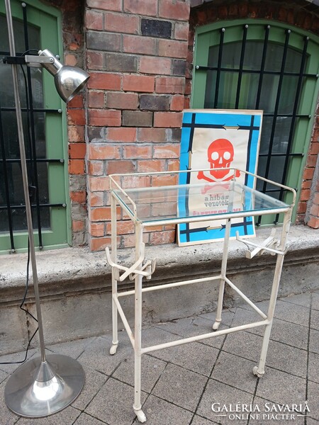 Old medical metal table on castors with fold-out tray holders