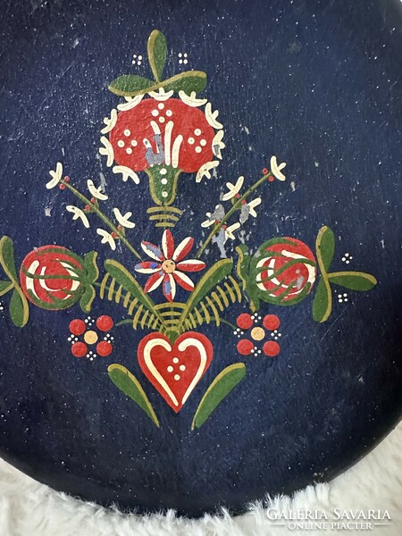 Wall plate with a flower pattern on a wood painted dark blue base