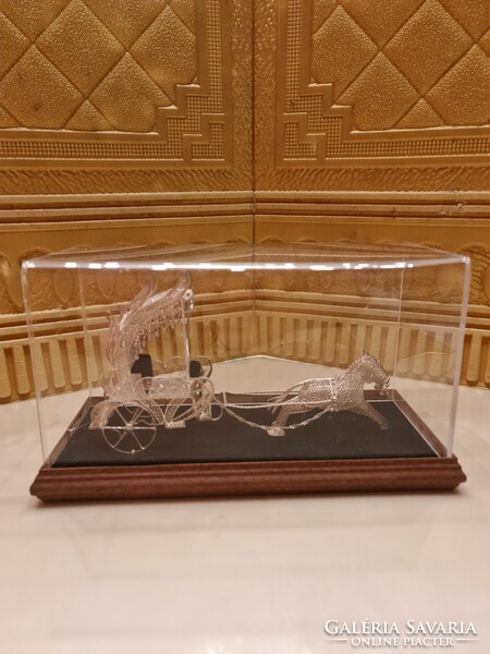 Unique filigree antique silver carriage on a wooden base in a plexiglass box