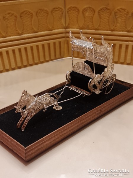 Unique filigree antique silver carriage on a wooden base in a plexiglass box