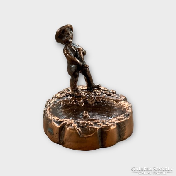 Old copper ring holder with a statue of a peeing boy