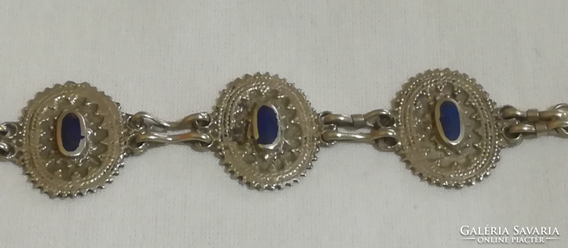 Metal bracelet with blue stones.