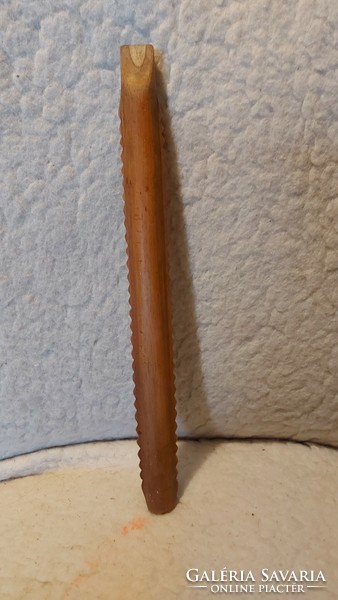 A folk wooden musical instrument with a carved tilinko