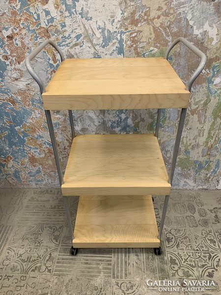 Modern folding trolley made of thick furniture board with a wood grain pattern, on a metal frame, with castors.