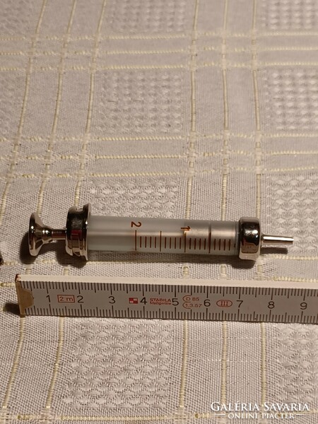 2 Ccm syringe in a metal holder, with 6 needles
