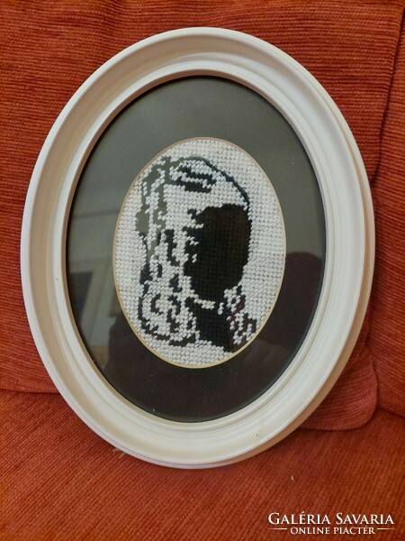 Gobelin shadow image of a woman's head in an oval frame