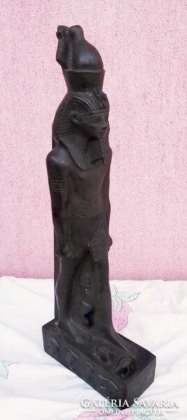 Black pharaoh standing statue in a circle with Egyptian symbols and hieroglyphs