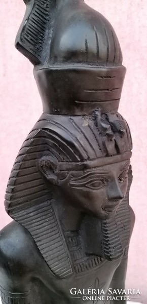 Black pharaoh standing statue in a circle with Egyptian symbols and hieroglyphs