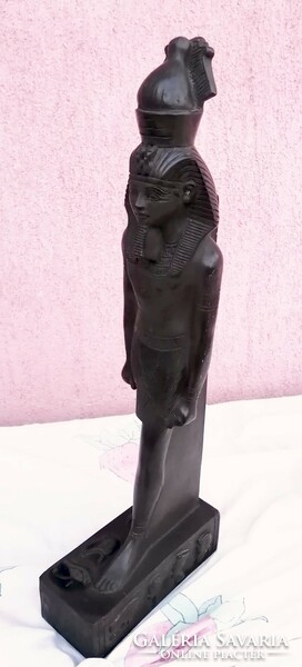 Black pharaoh standing statue in a circle with Egyptian symbols and hieroglyphs