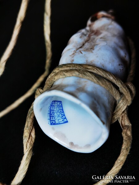 A porcelain brandy glass that can be hung around the neck in the shape of a pig's foot