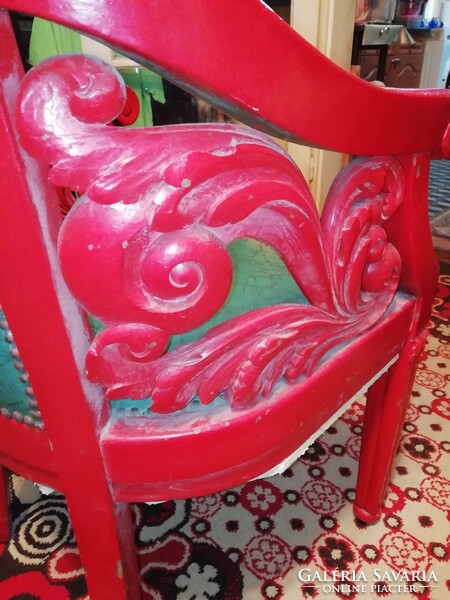 Antique armchair richly carved, leather reinforced at the bottom is a comfortable heavy piece
