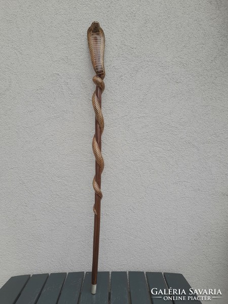 A wooden walking stick with a cobra head