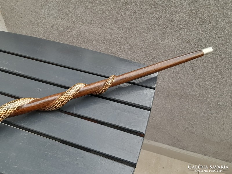 A wooden walking stick with a cobra head