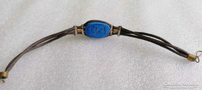 Blue scarab beetle on a leather bracelet