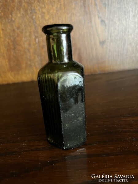 Old green medicine bottle with embossed inscription