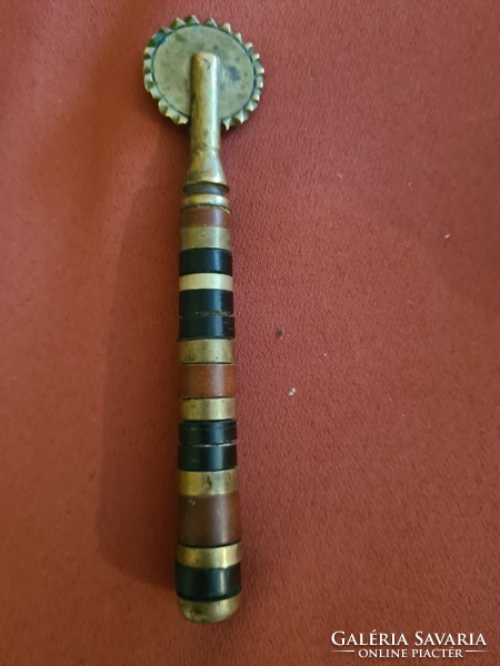 A brass cutter with a copper inlaid handle