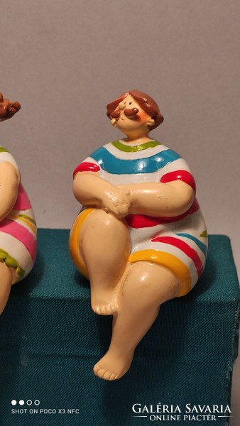 A charming pair of seated statues on a shelf