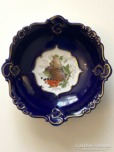 Decorative fruit bowl, gilded porcelain plate on a blue background with a fruit decoration in the middle, 26 cm