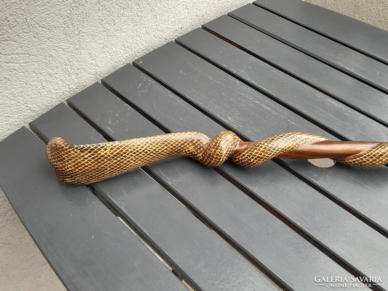 A wooden walking stick with a cobra head