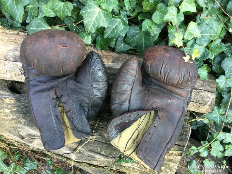 Old leather boxing gloves with straw-canvas lining