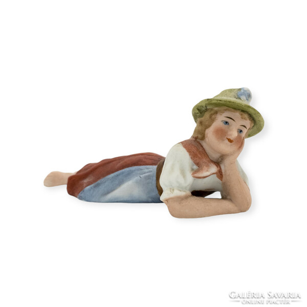 Alpine girl in a hat lying on a biscuit