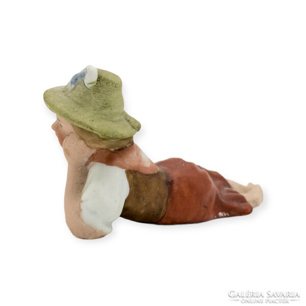 Alpine girl in a hat lying on a biscuit
