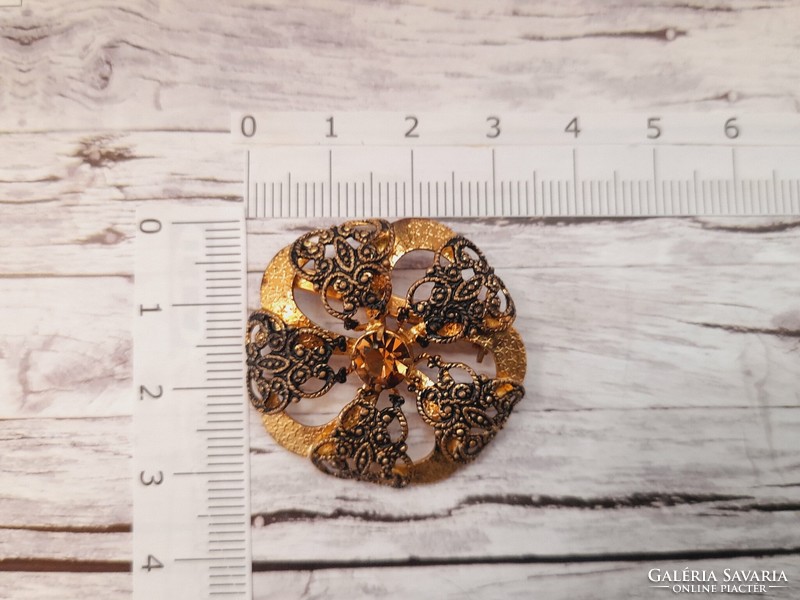 Golden brooch with rhinestones