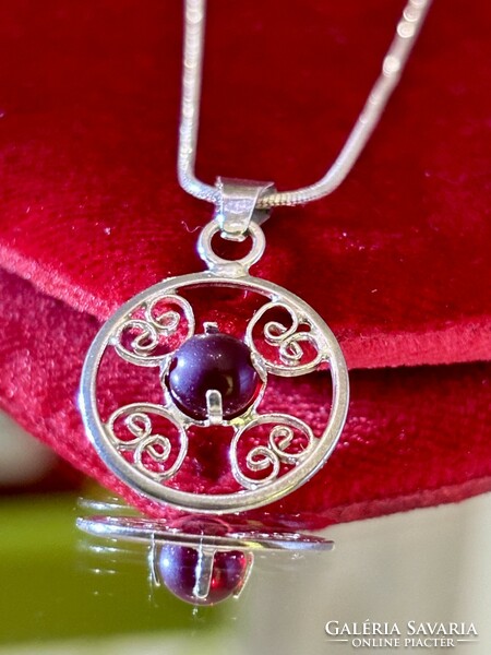 A beautiful silver necklace and pendant, embellished with a garnet stone