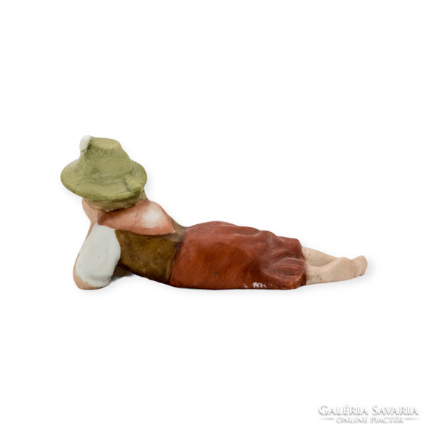 Alpine girl in a hat lying on a biscuit