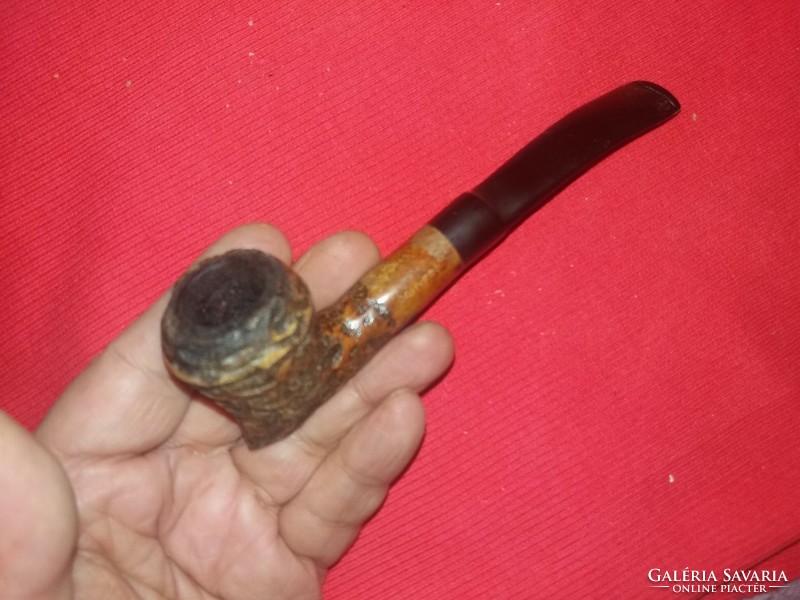 Old clay pipe with a slightly curved plastic stem / 