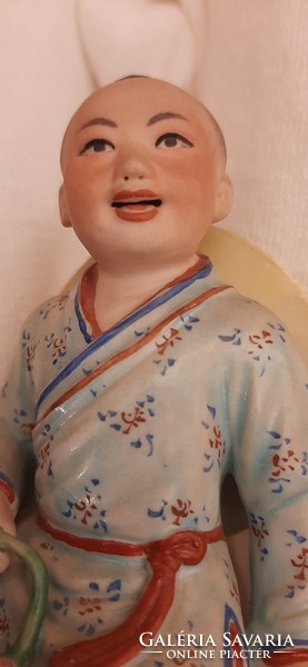 Chinese boy on the back of a buffalo with a rose in his hand. Detailed, hand-painted, 19 cm high porcelain statue.