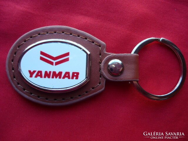 Yanmar metal keychain on a leather background