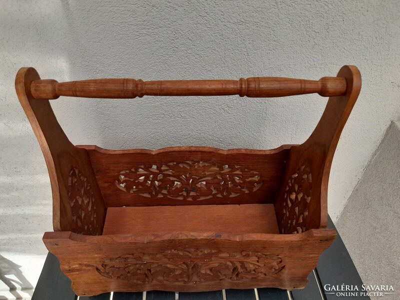 The whole thing is carved into a round, beautifully hand-carved wooden newspaper stand