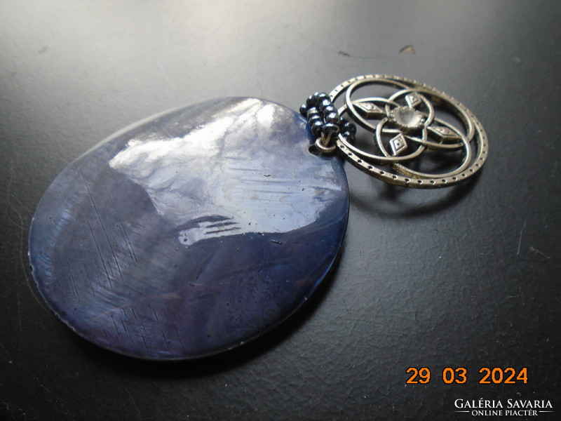 Shell and silver-plated Celtic pendant strung together, with a small metallic blue pearl hook