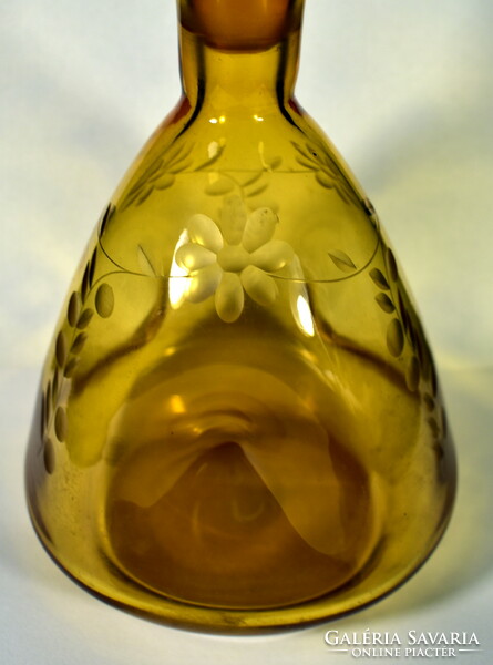 Amber colored liqueur bottle with an interesting shape with a polished cork