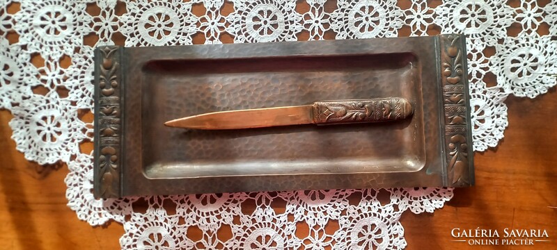 A copper/bronze leaf-cutting knife marked by an artisan on a tray