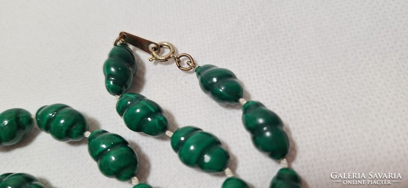 Green string of beads with a twist pattern