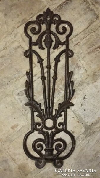 Wrought iron wall arms look very good in a wine cellar