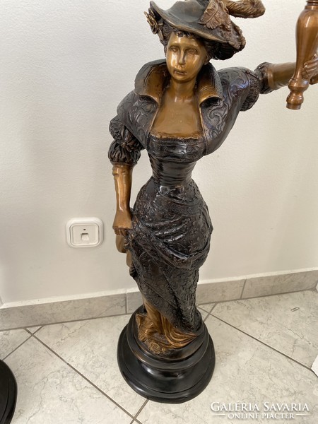 Bronze statue of a female figure holding a candle. He has a pair.