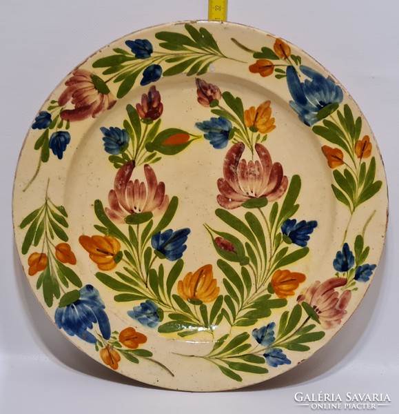 Folk ceramic wall plate with off-white glaze, marked 