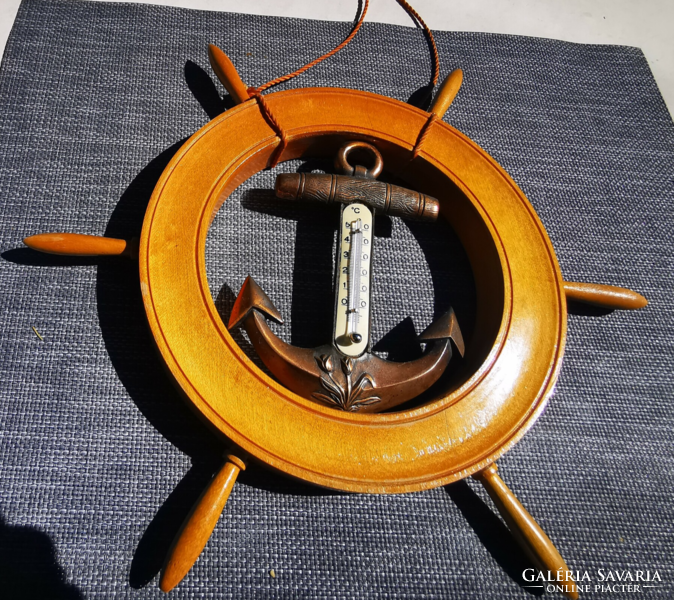 A wooden thermometer in the shape of a ship's rudder