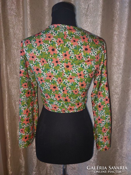 S-shaped floral top with bell sleeves. Novel