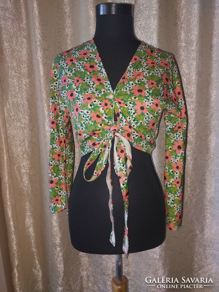 S-shaped floral top with bell sleeves. Novel